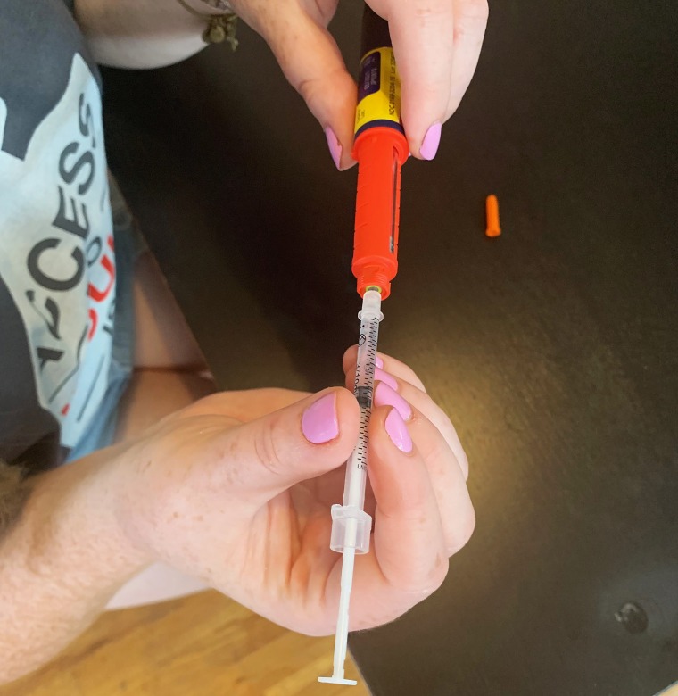 Allie Marotta, 25, demonstrates how she collects every drop of insulin out of her pen to save it for later use.