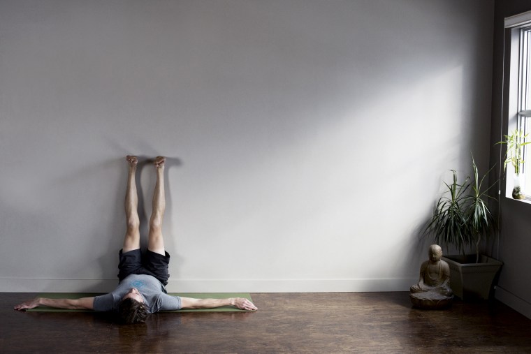Man lying on floor with his legs stretched out going up wall