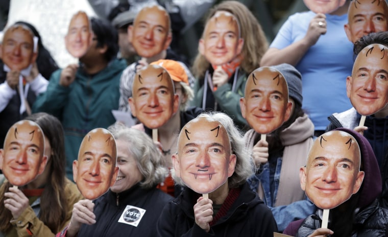 Demonstrators hold images of Amazon CEO Jeff Bezos during a Halloween-themed protest against Rekognition at Amazon headquarters in Seattle in 2018.