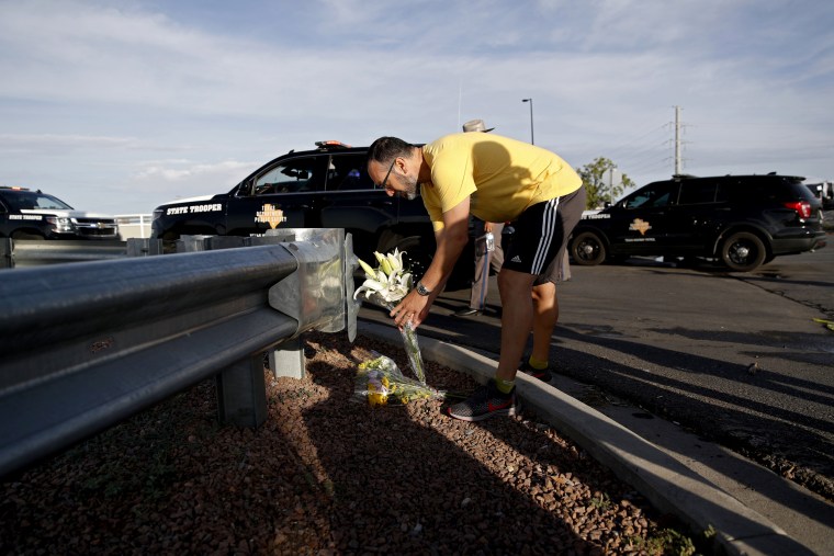 Image: A man leaves flowers near the scene of a mass shooting at a shopping complex in El Paso on Aug. 4, 2019.
