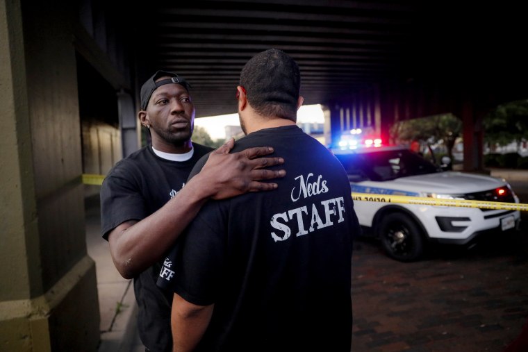 Image: Witnesses comfort one another at the scene of a mass shooting in Dayton, Ohio, on Aug 4., 2019. Nine people were killed and at least 27 were injured.