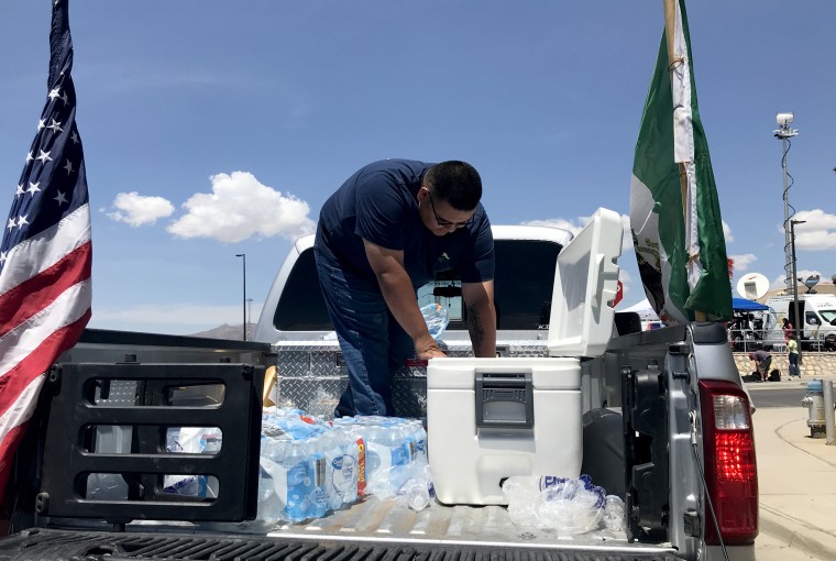 Image: Gabriel Gonzalez, 21, hands out bottles of water and soda near the Walmart.