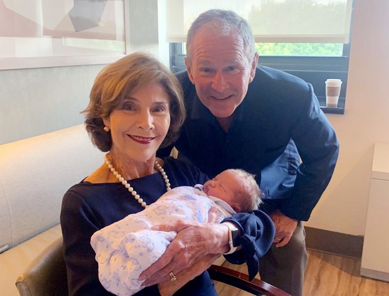 Former President George W. Bush and former first lady Laura Bush are all smiles as they hold their new grandson.