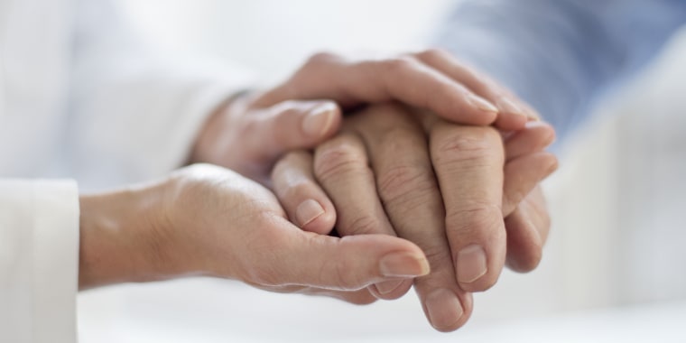 Caregiver holding hand