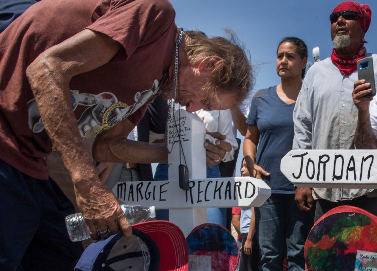 Antonio Basbo kisses the cross with the name of his common-law wife Margie Reckard who died in the shooting at a makeshift memorial after the shooting that left 22 people dead at the Cielo Vista Mall WalMart in El Paso, Texas, on August 5, 2019. - US President Donald Trump on Monday urged Republicans and Democrats to agree on tighter gun control and suggested legislation could be linked to immigration reform after two shootings left 30 people dead and sparked accusations that his rhetoric was part of the problem. \"Republicans and Democrats must come together and get strong background checks, perhaps marrying this legislation with desperately needed immigration reform,\" Trump tweeted as he prepared to address the nation on two weekend shootings in Texas and Ohio. \"We must have something good, if not GREAT, come out of these two tragic events!\" Trump wrote.