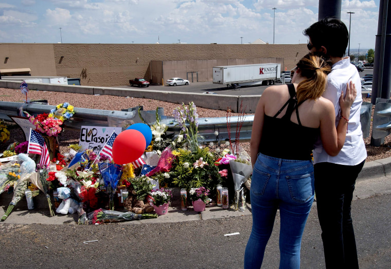 Image: Mourners hug next to a makeshift memorial outside the Cielo Vista Mall and Walmart a day after a mass shooting left 20 people dead in El Paso, Texas, on Aug. 4, 2019.