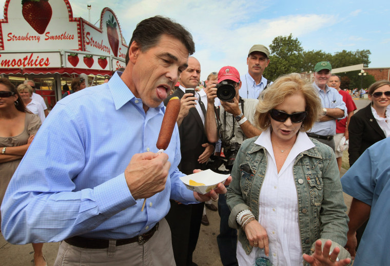 Image: Republican presidential candidate and Texas Governor Rick Perry tries a vegetarian corndog as he walks with his wife Anita at the Iowa State Fair