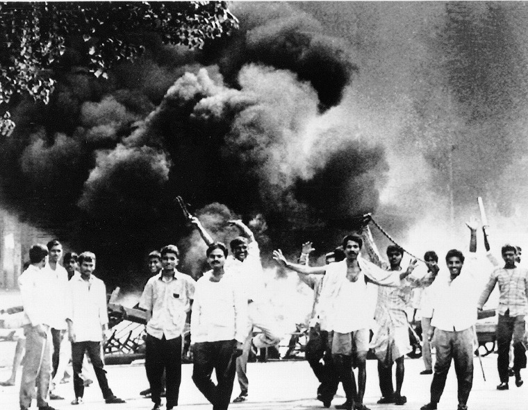 Hindu rioters walk down a street after setting a truck ablaze in Bombay, India on Jan. 10, 1993. Police fired on rioters, but sectarian fighting between Hindus and Muslims raged unchecked for a fifth day in the industrial city in western India.