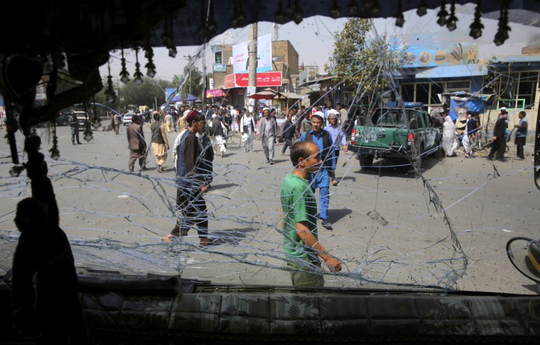 Image: Pedestrians are seen through a shattered bus window after an explosion in Kabul, Afghanistan, on Aug. 7, 2019.