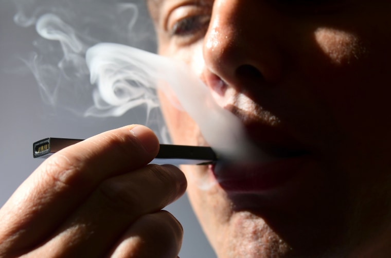 A man exhales smoke from an electronic cigarette.