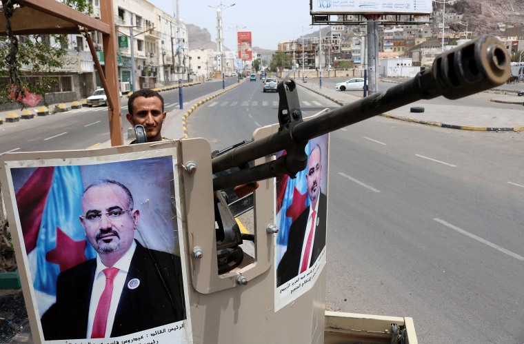 Image: A fighter mans the turret of a pickup truck mounted with an anti-aircraft gun displaying portraits of separatist leader Aidarus al-Zubaidi in Aden 
