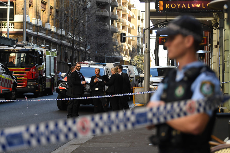 Image: Police gather at the crime scene after a man stabbed a woman and attempted to stab others in central Sydney