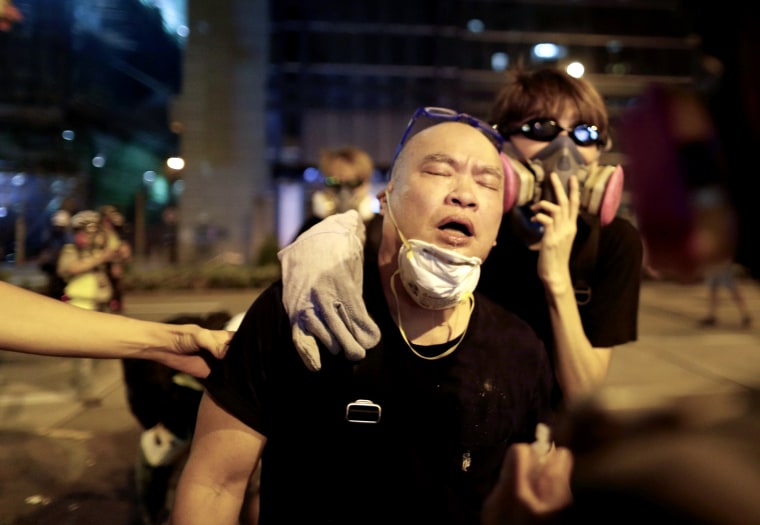 Image: A protester is helped after being tear gassed near the Shum Shui police station during demonstrations in Hong Kong on Aug. 14, 2019.