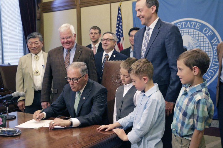 Gov. Jay Inslee signs a bill to make daylight saving time permanent in the state if federal law changes to allow it on May 8, 2019, in Olympia, Wash.