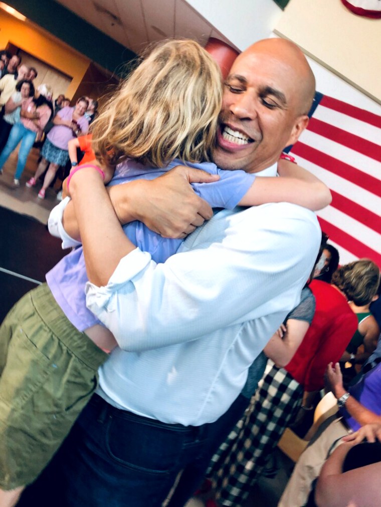 Image: Scout Maloney hugs Sen. Cory Booker, D-NJ, at an event in New Hampshire in July.