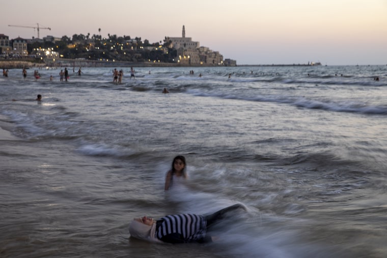 Palestinians sit in the beach during the Eid Al Adha festival in Tel Aviv after Israel granted travel permits to West Bank Palestinians on Aug. 14, 2019.