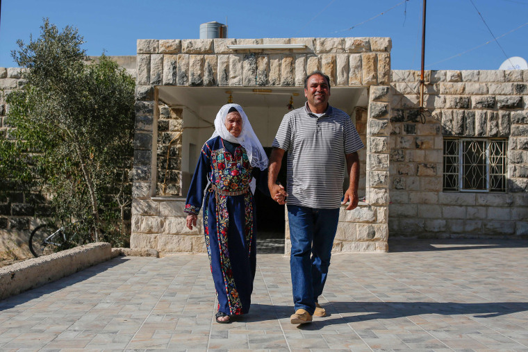 Image: Muftia Tlaib, the maternal grandmother of Congresswoman Rashida, walk with her son Bassam outside their home in the village of Beit Ur al-Fauqa, in the occupied West Bank