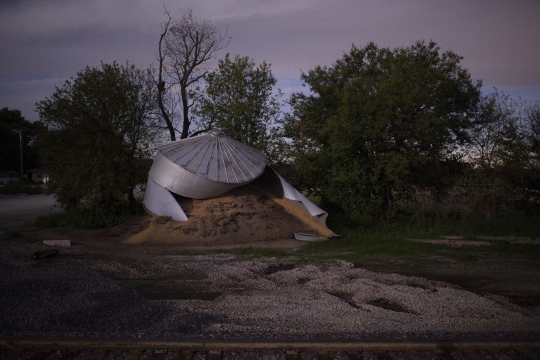 Image: Rotting soybeans spill out of a grain bin in Bartlett, Iowa, on August 14, 2019, five months after floodwaters first caused the metal structure to burst.