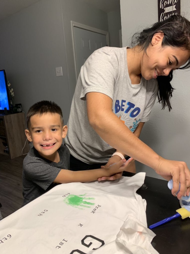 Carina Cansino and her son, Gus, add a handprint to the special shirt.