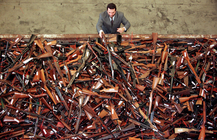 Image: Mick Roelandts, firearms reform project manager for the New South Wales Police, looks at a pile of about 4,500 prohibited firearms