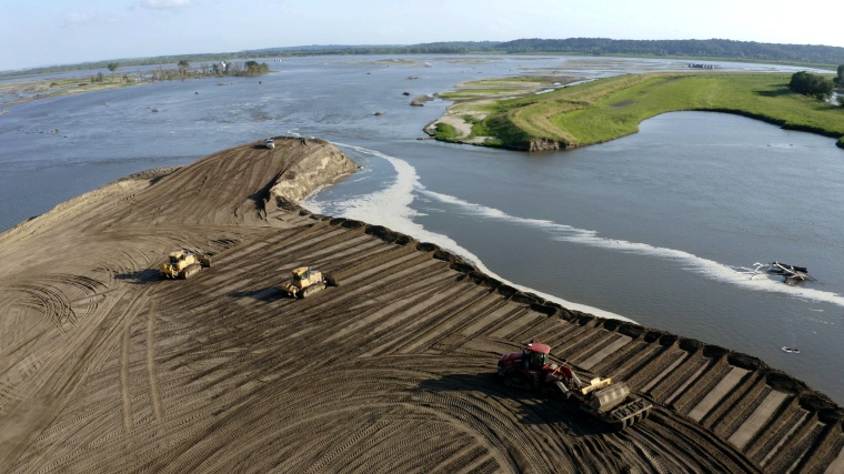 Image:  Bulldozers and other heavy equipment work to build a temporary repair of levee breach L550 near Watson, Missouri