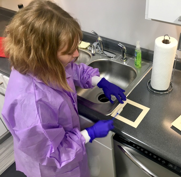 Meg Kirchner, a PhD candidate in food science and microbiology at NC State, swabs the area around the sink to look for contamination.