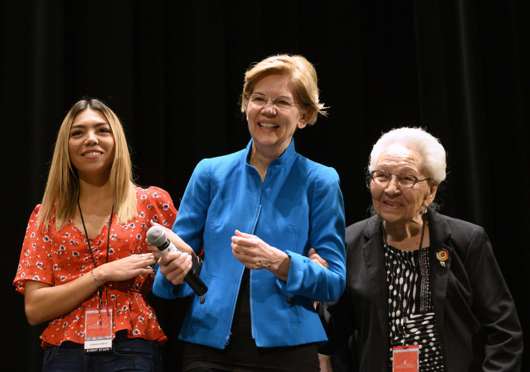 Image: Sen. Elizabeth Warren, D-Mass., is escorted on stage by Donna Brandis and Marcella LeBeau