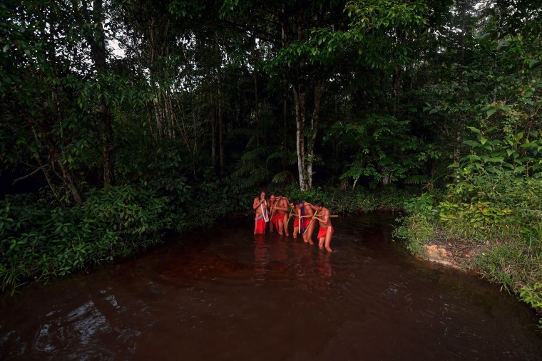 Waiapi men dance and play flute on the river in the Waiapi indigenous reserve in Amapa state in Brazil in 2017.