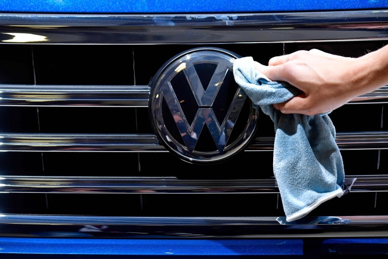 A staff member cleans the logo of a Wolkswagen ahead of the annual general meeting of the German carmaker in Berlin in 2018.