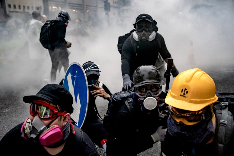 Image: Protesters clash with police in a cloud of tear gas in the Tsuen Wan district of Hong Kong on Aug. 25, 2019.