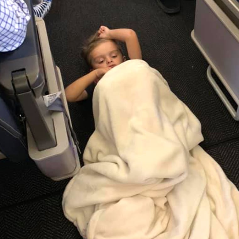 Passengers and crew help boy on airplane