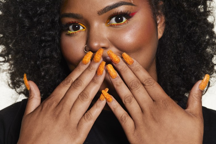 The "Caught Snacking" nails will add the perfect touch to your Cheetos look.