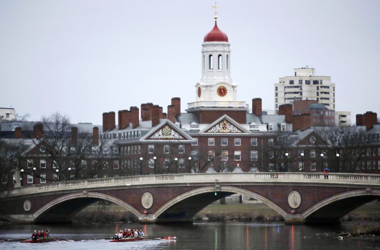 Image: Rowers paddle along the Charles River past the Harvard College campus in Cambridge