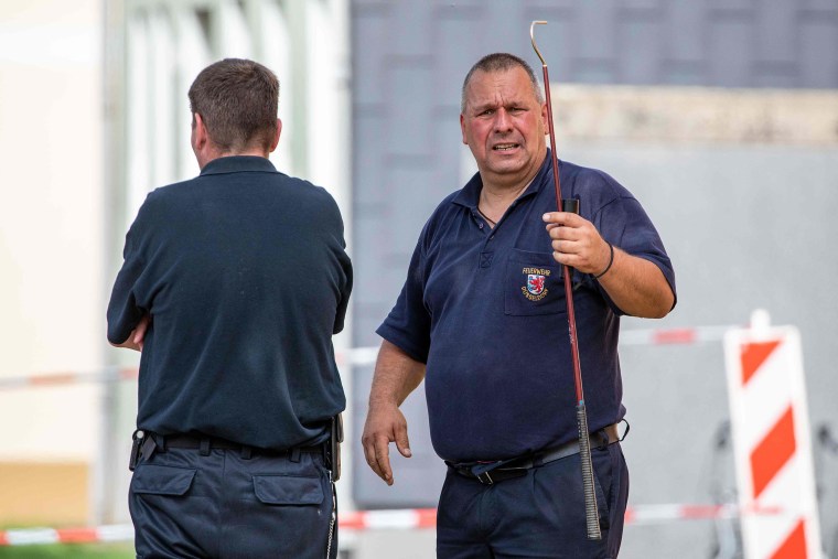 Image: Snake experts at work in front of a residential building in Herne, western Germany, where a deadly cobra was on the loose.