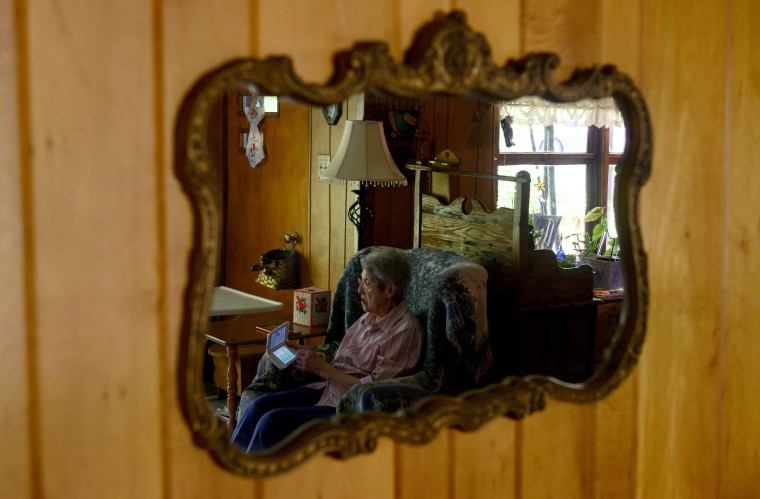 Image: Audrey Buchanan, 88, is reflected in a mirror while she plays Animal Crossing on her pink Nintendo 3DS XL
