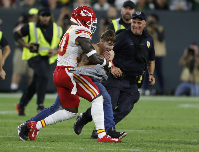 Image: Kansas City Chiefs' Harold Jones-Quartey tackles a fan that ran on the field during the second half of a preseason NFL football game against the Green Bay Packers