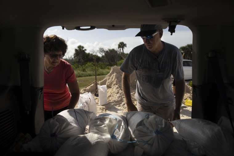 Leonel and Fionnuala Dominguez stack sandbags in their car in hopes of protecting their home in Sea Colony, Fla., as Hurricane Dorian made its way along the state's east coast on Aug. 31, 2019. The couple, who have only lived in their home full-time for a year, said they planned to evacuate to their daughter's house in Atlanta if Flagler County ordered a mandatory evacuation.