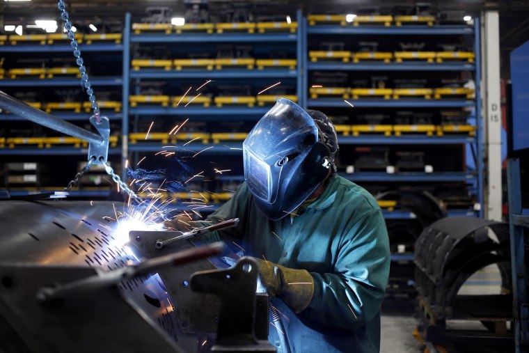 Image: A worker welds metal components onto a round baler at the New Holland Ltd. Haytools assembly plant in New Holland, Pennsylvania, on Dec. 19, 2018.