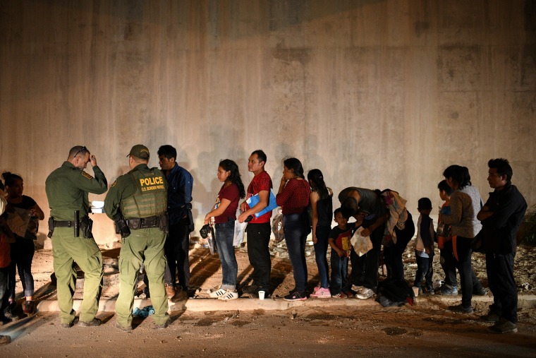 Image: Migrant families turn themselves to U.S. Border Patrol to seek asylum following an illegal crossing of the Rio Grande in Hidalgo