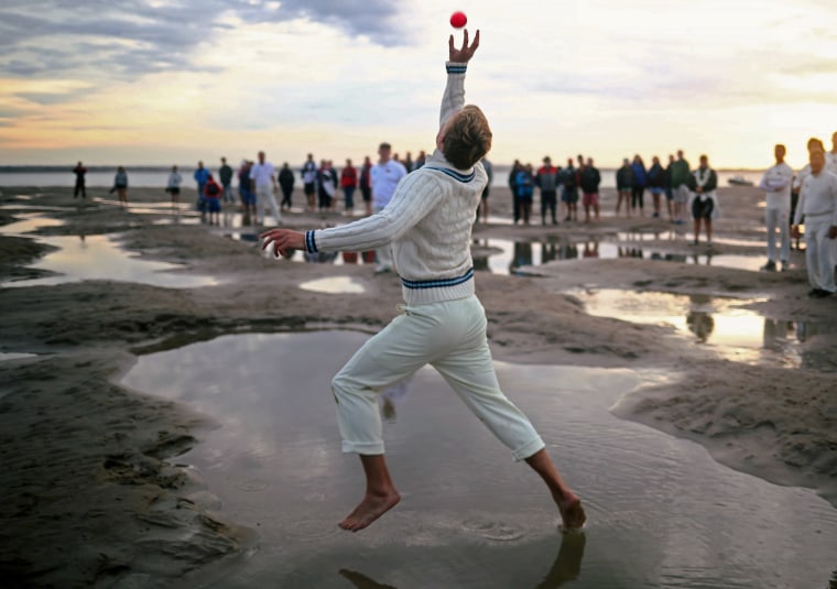 Image: A player participates in the annual Brambles Sandbank cricket match at low tide in the Solent