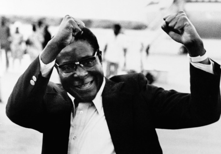 Image: Robert Mugabe raises his fists in salute to a group of supporters as he arrives at Lusaka Airport, Zambia.