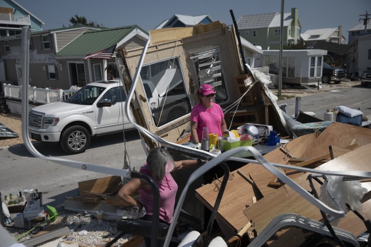 Mary Wells (right) and Charlene Lewis help sift through the rubble of their friend Arlene Cotty's mobile home Saturday in Emerald Isle, North Carolina. The mobile home was destroyed by a tornado caused by Hurricane Dorian days before. Cotty said she wasn't sure if she would be able to rebuild again after she had lost her home a year earlier in Hurricane Florence.