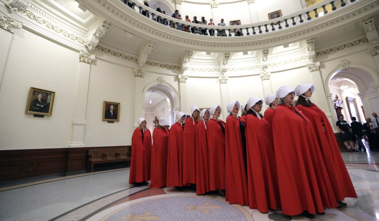 Image: Activists dressed as characters from The Handmaid's Tale chant in the Texas Capitol Rotunda