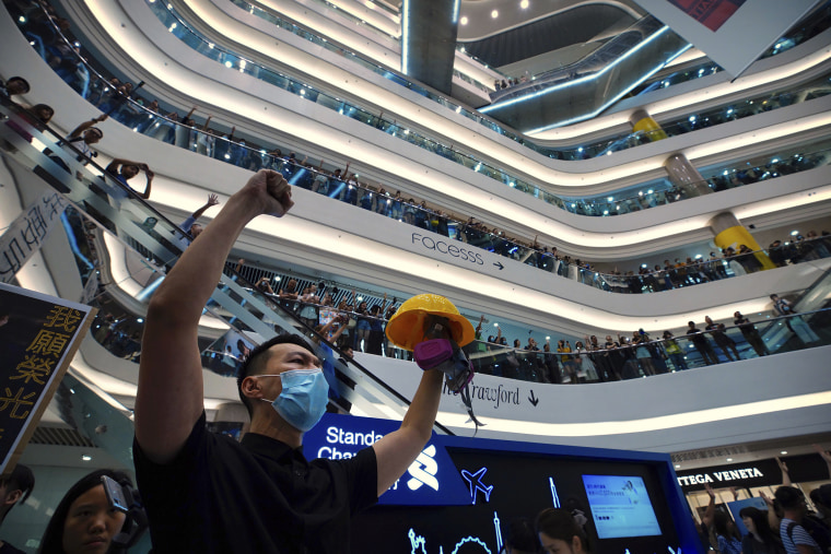 Image: Demonstrators sing a theme song written by protestors "Glory to Hong Kong" at the Times Square shopping mall in Hong Kong