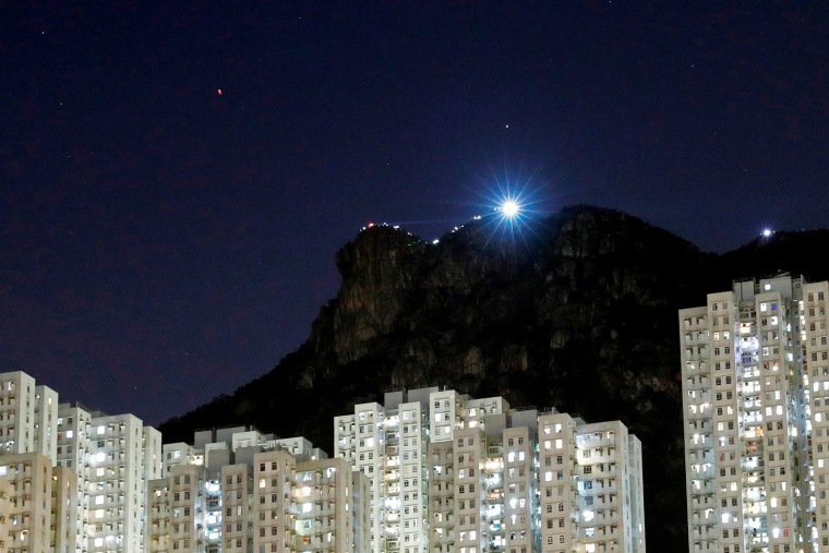 Image: Anti-extradition bill protesters light up their smartphones as they form a human chain during a rally to call for democracy and political reforms, on top of the iconic Lion Rock, at Wong Tai Sin