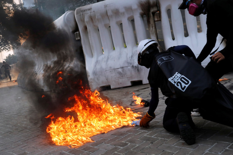 Image: Anti-government protester prepares to throw a Molotov cocktail during a demonstration near Central Government Complex in Hong Kong