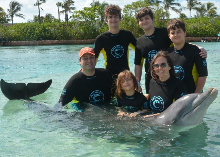 Four kids means swimming with dolphins is a once-in-a-lifetime splurge, because traveling is crazy expensive. (But also worth it, because dolphins!)