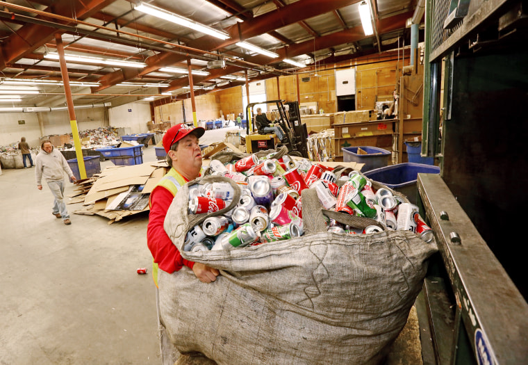 Allan Lamprey with a bag of aluminum cans in front of the crusher at the Fairbanks North Star Borough Central Recycling Facility in Fairbanks, Alaska.