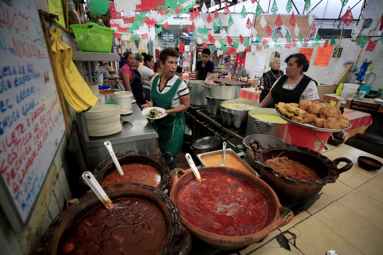 Image: Maribel Sanchez carries a chile en nogada at El Sabor, a family-owned restaurant, in Mexico City on Sept.10, 2019.