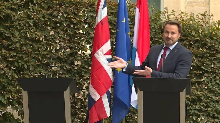 Image: Luxembourg's Prime Minister Xavier Bettel gestures to an empty podium as he speaks to the press after a meeting with the British Prime Minister, EU Commission President and officials in Luxembourg